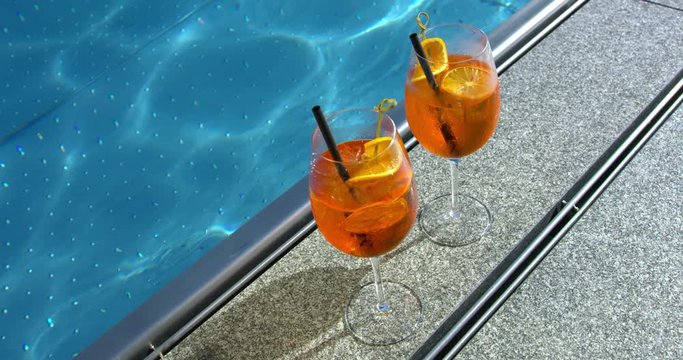 Full shot, Glasses of Orange Cocktail on the side of the pool, relaxation, spa time.