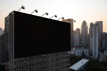 Blank black road billboard with Bangkok cityscape background at sunset. Street advertising poster,...