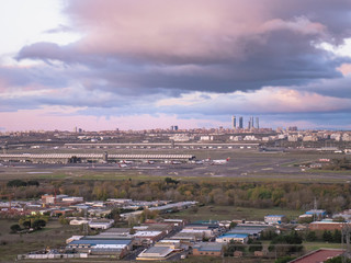 Spectacular cloudy sky at sunrise at Adolfo Suárez Madrid-Barajas Airport with the city of Madrid and the Cuatro Torres Business Area (CTBA), spectacular sky sunrise