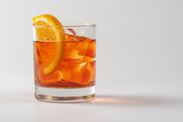 Alcoholic cocktail with orange in glass glass on white background