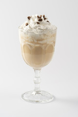 Coffee-chocolate milk protein shake, with whipped cream and caramel syrup on a white plate.