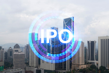 IPO icon hologram over panorama city view of Kuala Lumpur. KL is the hub of initial public offering in Malaysia, Asia. The concept of exceeding business opportunities. Double exposure.