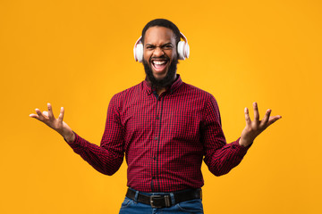 Smiling afro man enjoying music using headset