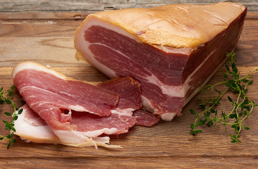 chopped into pieces of prosciutto on a brown wooden board