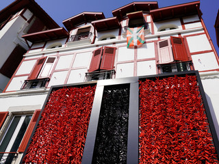 Red and black peppers hanging drying at the facade of typical Basque house
