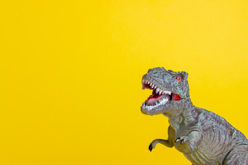 Dinosaur on a yellow background. Toy. Creative idea. Concept.