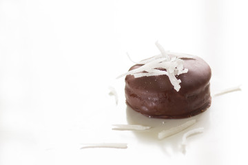 Homemade chocolate pie with coconut chips on top on the white background