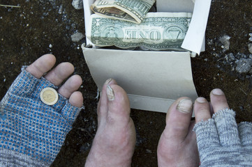 A coin in the hands of a homeless man in gloves. Poverty, unemployment, hunger.