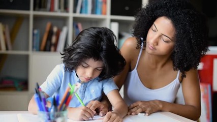 mother doing tutoring with her son at home