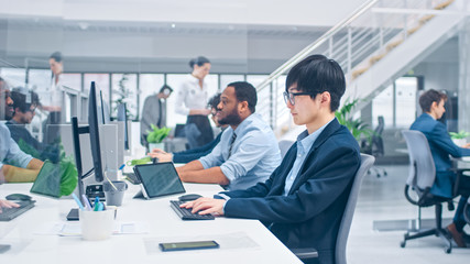 Shot of a Young Japanese Business Specialist Works on Desktop Computers. Diverse Team of Young and Motivated Businesspeople in Modern Open Office.