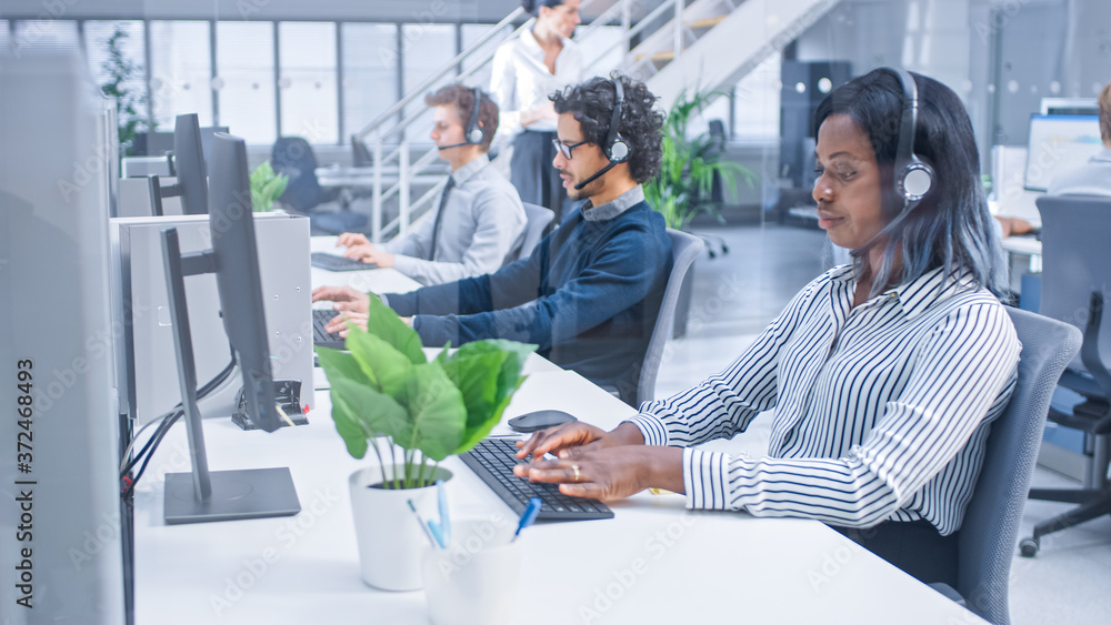 Poster Team of Handsome and Beautiful Diverse Multicultural Customer Service Operators Working at a Busy Modern Call Center with Specialists Wearing Headsets and Actively Taking Calls. 