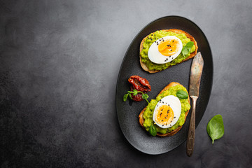 Healthy breakfast, toast with avocado and egg, top view, copy space. Vegetarian food concept