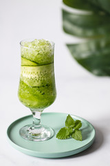 A glass of fresh detox cucumber water with crushed ice. Refreshing summer drink. Light background, copy space 