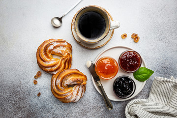 Fresh and bright continental breakfast table with buns with cottage cheese, coffee and jam, top view