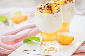 Healthy strawberry, peach and walnut parfait in a glass on a white background