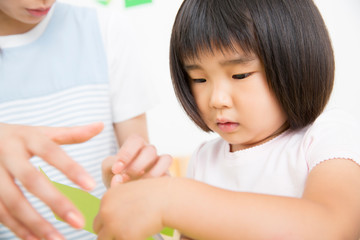 工作をする幼稚園児と先生