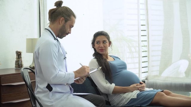 gynecologist doctor examining and consulting to pregnant woman in medical office at at hospital