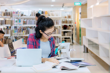 Obraz na płótnie Canvas Female student study with laptop while read books