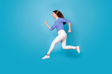 Full length body size profile side view of her she attractive cheerful cheery girl jumping running marathon sprint distance isolated bright vivid shine vibrant blue color background
