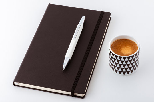 Carnet de note et son stylo avec une tasse à café