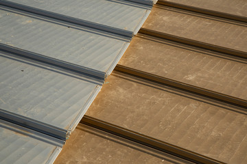 Obraz premium Metallic aluminum sheets in steel and gold color on the roof. close-up