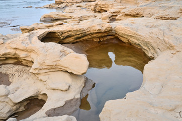 Clear water in small stone pond beside the river