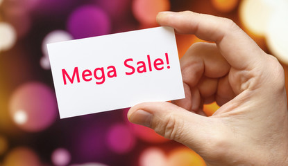 Mega Sale - the inscription on the card that the person is holding.