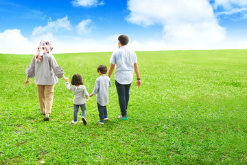 Obraz premium Happy family walking together at field