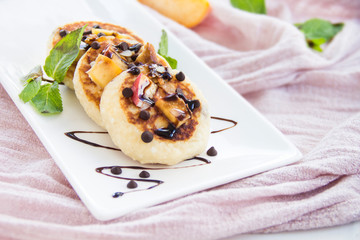 A healthy breakfast of pancakes, peach, chocolate, and honey