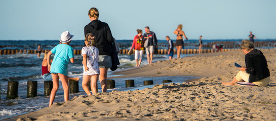 A mother with children walking on the beach by the Baltic Sea