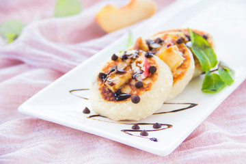 A healthy breakfast of pancakes, peach, chocolate, and honey