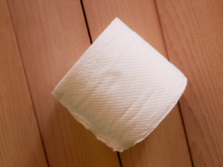 Simple toilet paper on wood background.