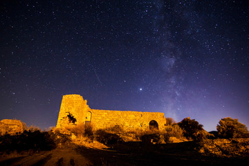 night view of the castle. A view of the stars of the Milky Way with a mountain top in the...