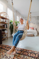 Alternative girl swinging in a hammock at home