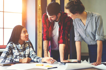 Classmates working together on coursework project cooperating and sharing ideas to get good mark and continue education in college communicating in friendly atmosphere in campus after lessons