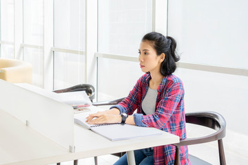 Young blind woman reading a braille book in library