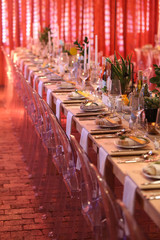 table setting in a room with red lighting for an event.