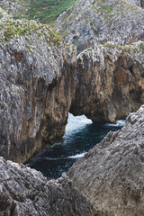 Cliffs of the Cantabria coast next to the beach on a cloudy day