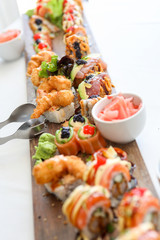 Fresh colorful sushi served on a wooden board.