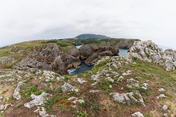 Cliffs of the Cantabria coast next to the beach on a cloudy day