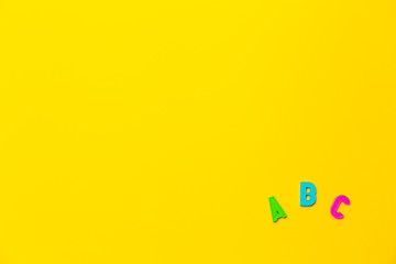 Multicolored letters A, B, C of the alphabet on yellow background. Learning foreign language for beginners. Primary school education, grammar lesson. Banner on educational theme with free text space