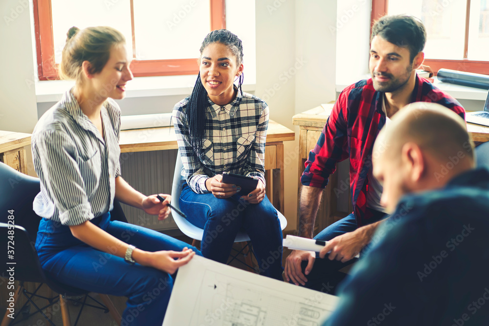 Poster diversity team of cheerful creative designers in stylish casual clothing discussing successful ideas