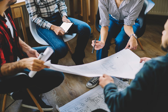Young concentrated professionals collaborating on design planning and searching useful information on webpages for improving architectural sketch on digital touch pad connecting to 4G internet
