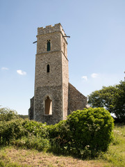 remians of a derelict church tower in mid norfolk england on a bright summers day