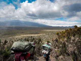 Cercles muraux Kilimandjaro guides porters and sherpas carry heavy sacks as they ascend mount kilimanjaro the tallest peak in africa.