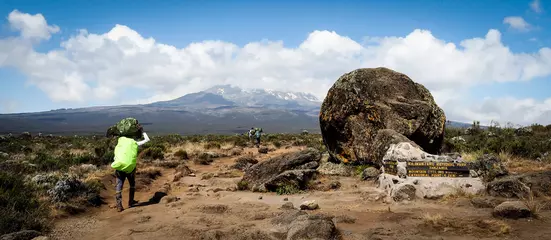 Foto op Plexiglas Kilimanjaro gidsen dragers en sherpa& 39 s dragen zware zakken terwijl ze de Kilimanjaro beklimmen, de hoogste bergtop van Afrika.