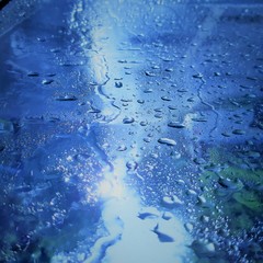 water drops on a glass surface  and a light stream cutting through them.