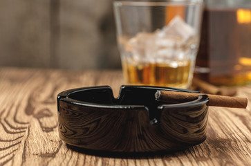 Lighted cigar in an ashtray close up