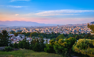 View of Athens and its residential areas from Pnyx hilltop in soft evening sunlight with great sunset sky