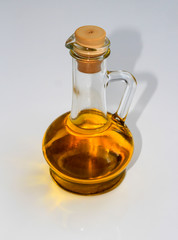 Olive oil in a bottle on a white table.